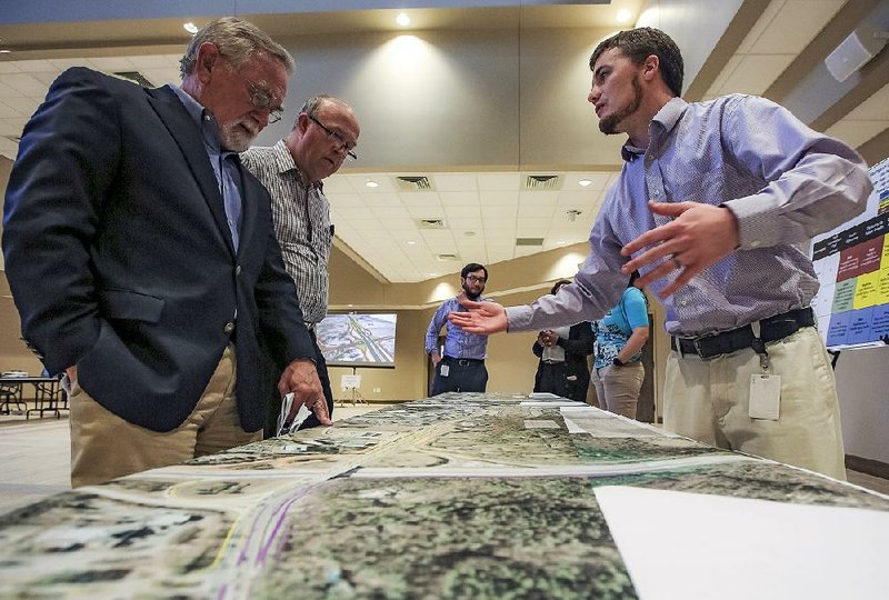 Jim McKenzie of Little Rock (from left) and Glynn Fulmer of Conway listen to Daniel Byram, a transportation planning engineer for the state Highway and Transportation Department, talk about the plan for the Cantrell Road/Interstate 430 interchange project Thursday during a public information session at Christ the King Church in Little Rock.