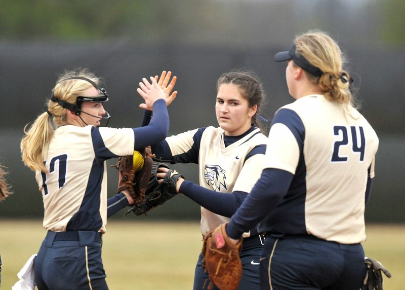 Bentonville West teammates Emma Wood (from left), Alyssa Cordell and Anna Griffin high-five Thursday after making an out against Springdale Har-Ber at Bentonville West in Centerton.