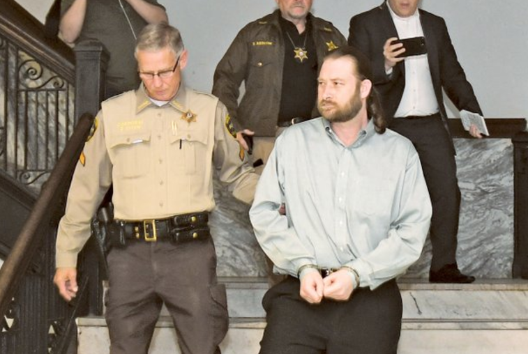 The Sentinel-Record/Mara Kuhn Garland County sheriff's bailiff Ronnie Dunn, left, escorts Kevin Duck out of court Thursday in Hot Springs.
