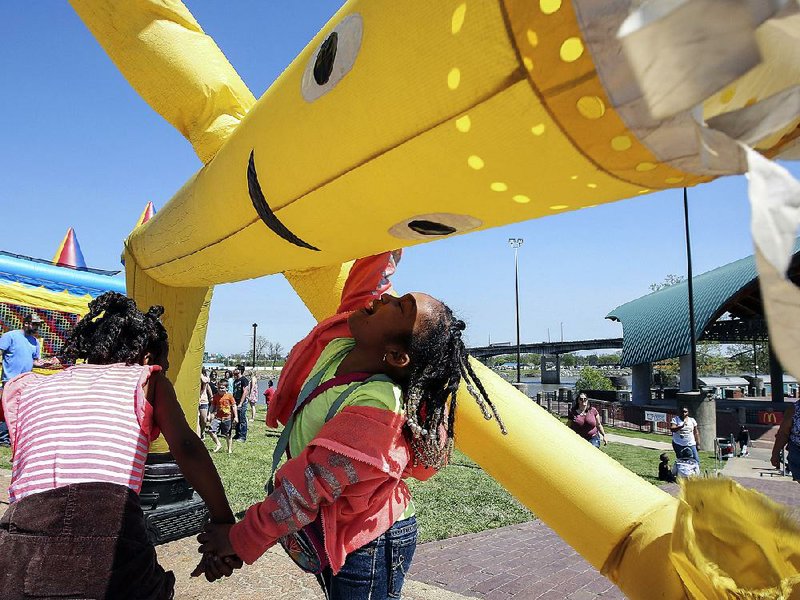 Arkansas Democrat-Gazette/MITCHELL PE MASILUN --4/1/2017--
Six year old Robin McClain, center, of Little Rock and her friend Kaitlynn Johnson, 9, also of Little Rock, have fun with an inflatable air dancer during Springfest in downtown Little Rock Saturday, April 1, 2017.  For more photos go to www.arkansasonline.com/galleries