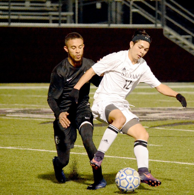 Michael Burchfiel/Siloam Sunday Christian Marroquin played the ball past McAlester center back Jonathan Wunden Saturday night. The Panthers won 2-0 at home.