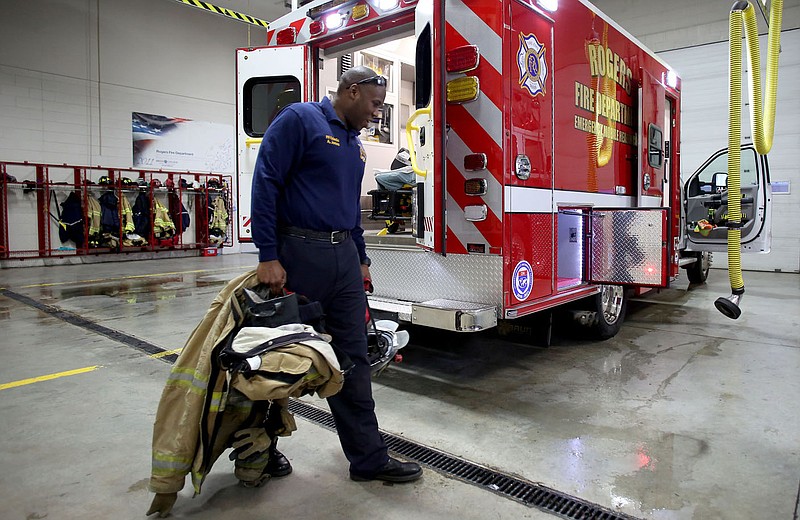 NWA Democrat-Gazette/DAVID GOTTSCHALK Al Jones, Rogers firefighter and medic, stows his fall-out gear Frida on Medic 1 at Fire Station No. 1 at the beginning of his shift.