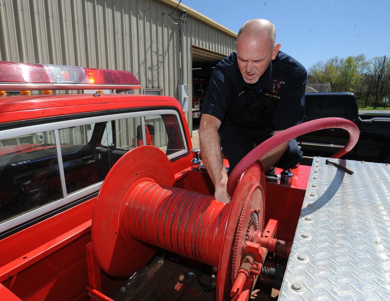 West Fork fire chief Mark Myers installs a new hose on the department’s brush truck Friday in West Fork. City officials plan to make $1.28 million in improvement and expansion to administrative and police offices and to the city’s public library.