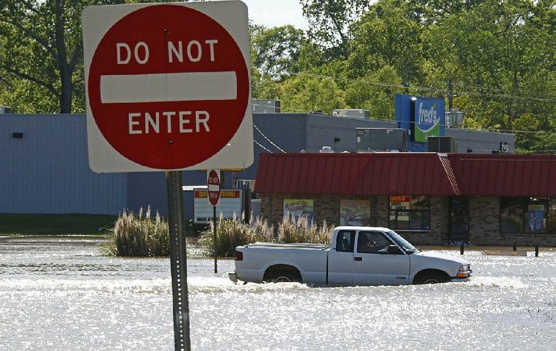 A pickup rolls slowly through fl oodwaters Monday in Pelahatchie, Miss.