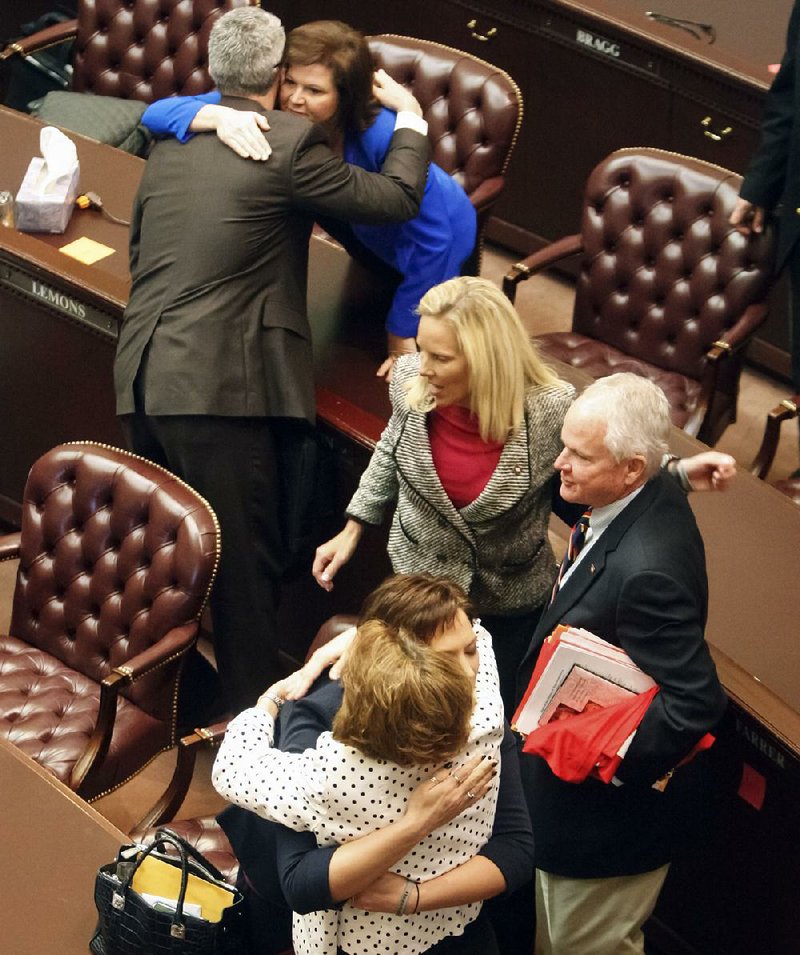 Lawmakers embrace on the fl oor of the House on Monday after Speaker Jeremy Gillam, R-Judsonia, gaveled the 91st General Assembly into recess. The next meeting will be May 1, when the session is to officially adjourn.