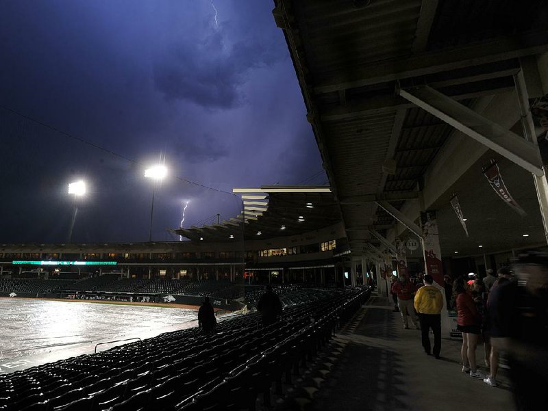 Lightning strikes above Baum Stadium in Fayetteville during a rain delay in the Arkansas Razorbacks’ game against Grand Canyon on Tuesday night. The game was postponed in the second inning and will be completed today, beginning at 2 p.m. as part of a doubleheader.