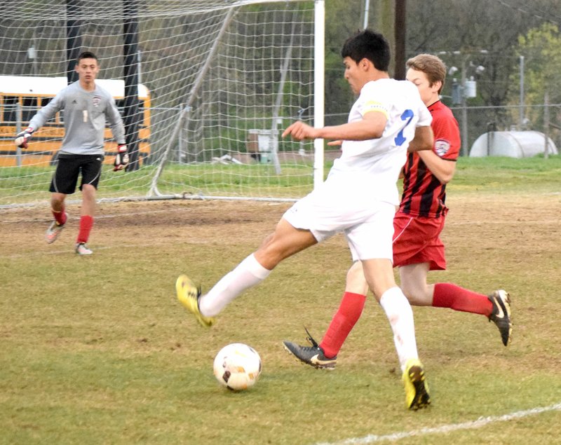 Photo by Mike Eckels Jafett Puga (Decatur, 7) moved the ball away from a Eureka Springs player as he tried to set up a shot during the second half of the Bulldog-Highlander soccer match at Bulldog Stadium in Decatur March 30. The Bulldogs lost the match in a 3-2 shootout in overtime.