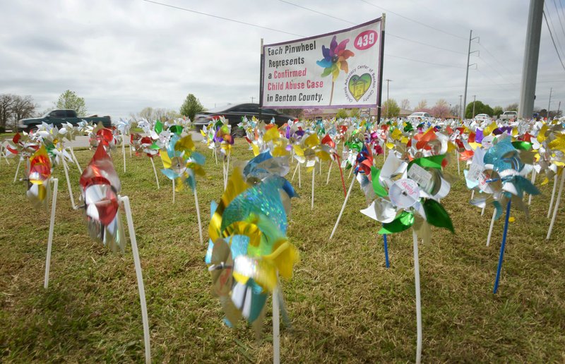 Pinwheels spin in the wind Friday, March 31, 2017 in front of the Benton County Sheriff's Office in Bentonville. In participation with the Children's Advocacy Center of Benton County's annual Cherishing Children Pinwheels campaign, sites in Benton County will feature displays, each with 439 pinwheels, during April, which is National Child Abuse Prevention Month. The pinwheels represent the 439 confirmed child abuse cases in the county in 2016. Additional displays of 50 pinwheels can be seen at sponsoring businesses. 