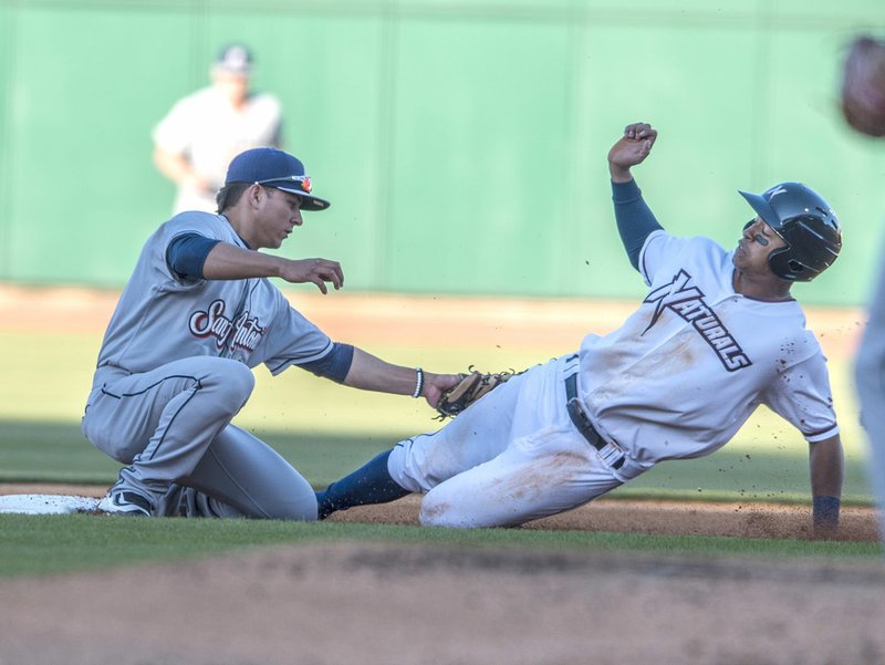 Alfredo Escalera (right) of the Northwest Arkansas Naturals is tagged out by Luis Urias of the San Antonio Missions on Thursday at Arvest Ballpark in Springdale.