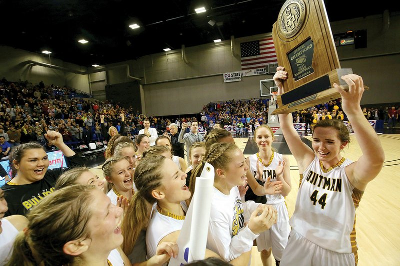 Quitman’s MVP Reagan Rackley, right, lifts the trophy into the air after the Lady Bulldogs defeated Hector during the Class 2A State Championship basketball game March 11 in Hot Springs.