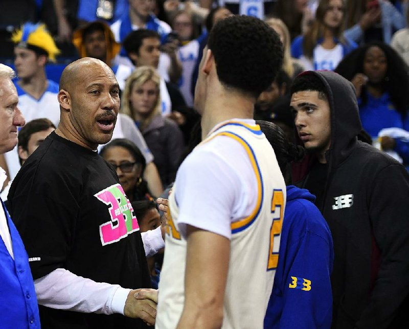  In this March 4, 2017, file photo, UCLA guard Lonzo Ball, right, shakes hands with his father LaVar following an NCAA college basketball game against Washington State in Los Angeles.  LaVar Ball has backed off comments he made Thursday suggesting his son’s UCLA team lost in the NCAA Tournament because of three white players who were slow afoot.