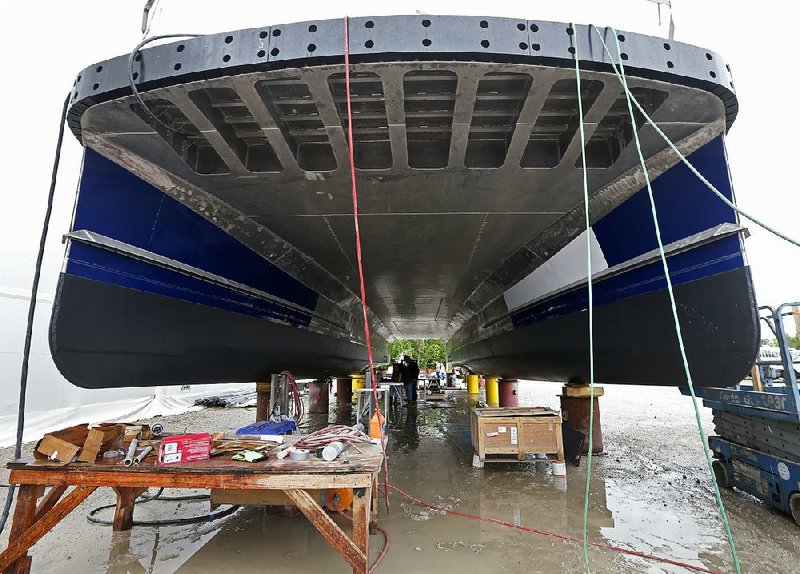 Workers toil underneath one of several ferryboats being built for a new fleet of ferries for New York, at the Metal Shark Shipyard in Franklin, La., in late March.