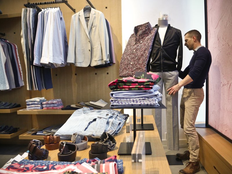 In this Monday, March 20, 2017, file photo, Bonobos manager Stephen Lusardi arranges clothing at the brand's Guideshop, in New York's Financial District. 