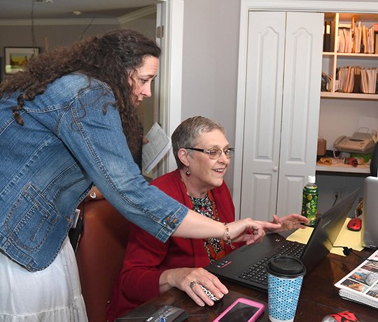 The Sentinel-Record/Mara Kuhn HOT SPRINGS GIVES: Erin Holliday, left, executive director of Emergent Arts, submitted a donation Thursday at the home of Dorothy Morris as Janet Harney, right, with the Arkansas Arts Council, provided assistance. Morris, president of the Morris Foundation, hosted the foundation's Garden Party of Giving to encourage local giving. Local donations surpassed her goal of $500,000.