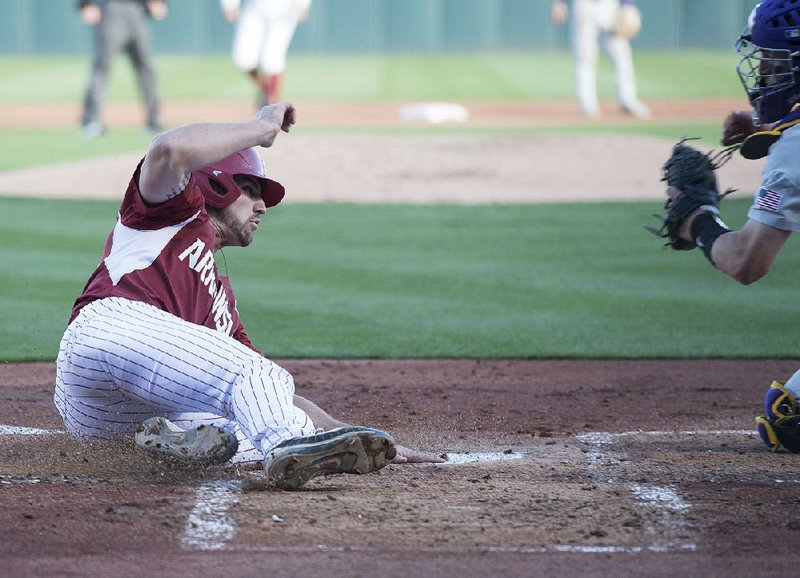 Arkansas first baseman Chad Spanberger slides safely into home plate Saturday ahead of a throw to LSU catcher Michael Papierski during the Razorbacks’ 10-8 loss to the Tigers at Baum Stadium in Fayetteville. Spanberger finished 3 for 5 with 2 runs scored and 5 RBI.