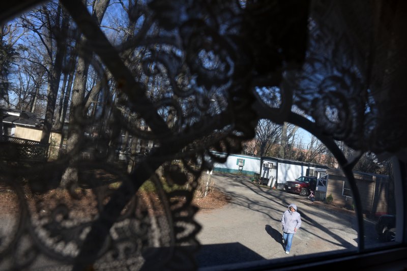 Lucia Zevala walks through the East End Mobile Home Park in Manassas, Va. Residents are facing eviction unless a deal can be made for a nonprofit group to purchase the park and make the necessary infrastructure improvements. 