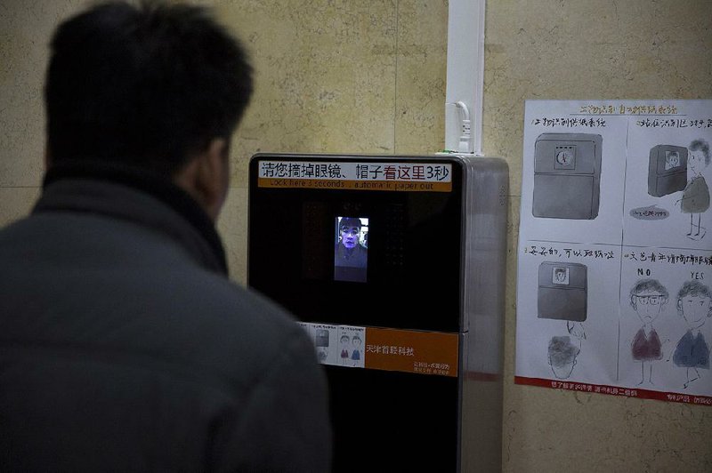 A man tries out a facial-recognition toilet-paper dispenser at a restroom in the Temple of Heaven park in Beijing in late March.