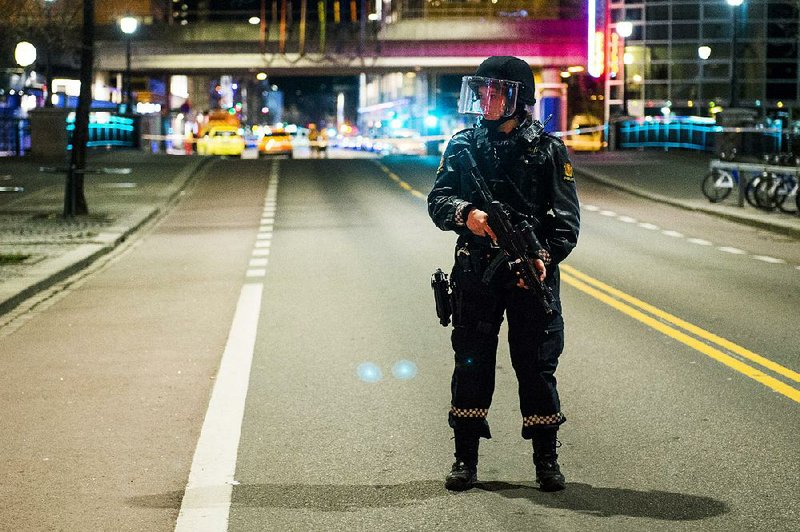 A Norwegian officer stands guard as police cordon off the area around a subway station on a busy commercial street in Oslo onSaturday night after finding what they described as a “bomb-like” device.