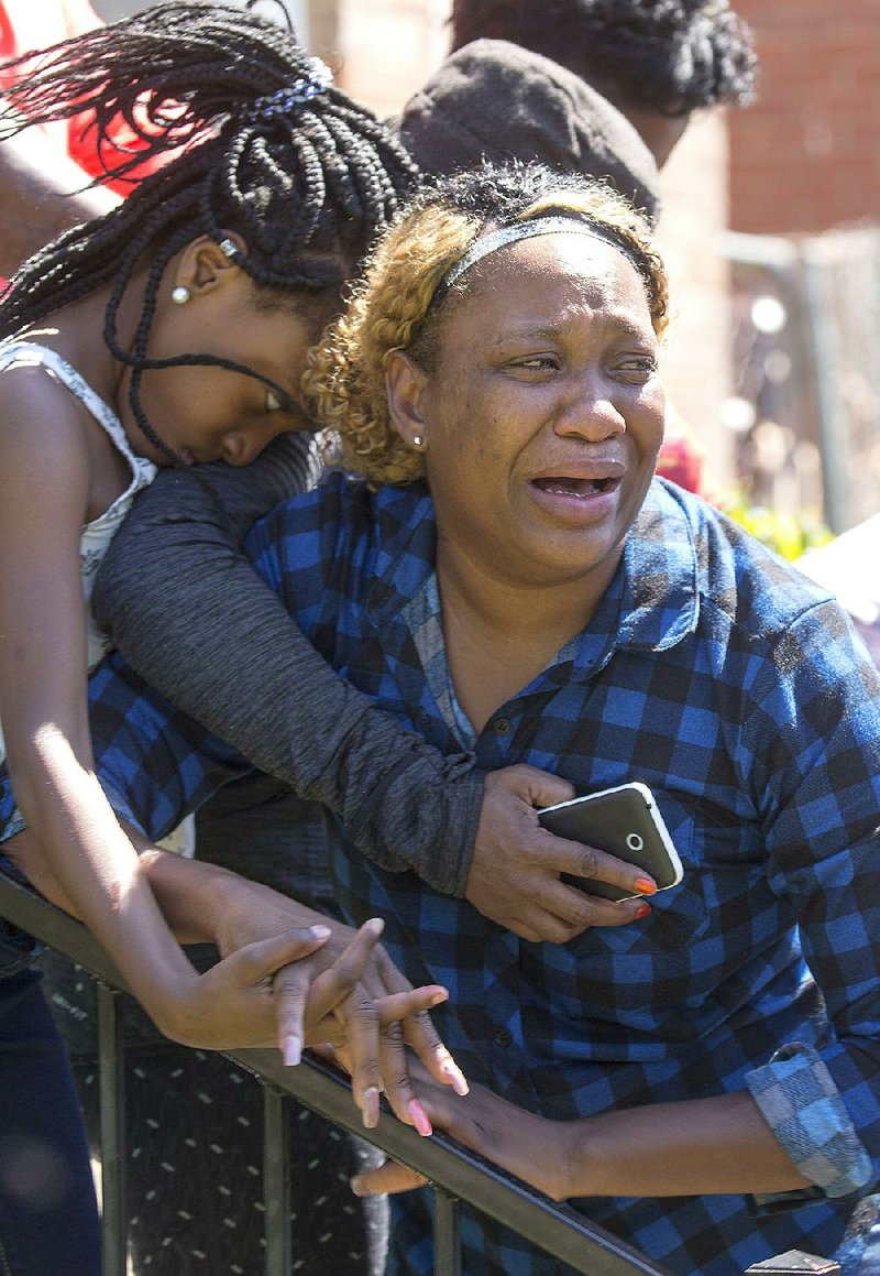 Catorius Thomas, sister of homicide victim Rodney Austin, weeps with family members at a memorial service at their mother’s home in Little Rock on Sunday.