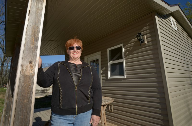 Sharon Whelchel stands on the porch of the “tiny house” Friday which will serve as a guest house on her property in Garfield. Whelchel has founded Arkansas Veterans Village, a nonprofit group trying to build a housing project with small houses of about 400 square feet for homeless and struggling military veterans in Northwest Arkansas.