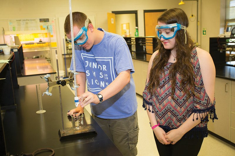 Searcy High School juniors Michael Kidd, left, and Anna-Catherine King set up a titration experiment. Kidd and King recently competed in the Chemistry Olympiad at the University of Arkansas at Little Rock. King took first place, while Kidd won second.