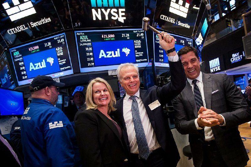 David Neeleman, founder and chief executive officer of Brazilian airline Azul SA, holds up a gavel Tuesday as he’s joined on the floor of the New York Stock Exchange by Ali Neeleman (left) and NYSE Group Inc. President Thomas Farley after ringing a ceremonial bell during Azul’s initial public offering. U.S. stock indexes barely moved Tuesday in another day of light trading. 