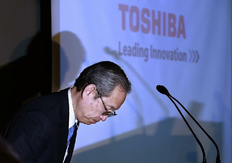 Satoshi Tsunakawa, Toshiba’s chief executive, bows Tuesday during a news conference at the company’s headquarters in Tokyo. “We will do what we can to avoid being delisted from the stock exchange,” Tsunakawa said as he apologized to shareholders for the company’s performance.