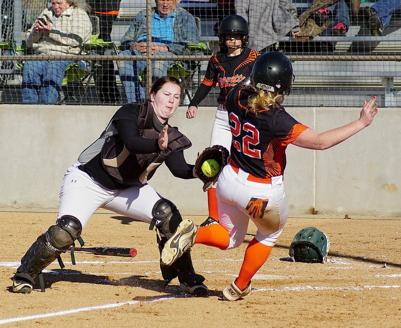 Photo by Randy Moll Sydney King slides into home and is tagged by Greenland catcher Kaitlyn Sutton but is safe because the catcher dropped the ball during play between the two teams in Gravette on Thursday, April 6, 2017. Keeley Bulza (in the background) was up to bat when the play ocurred.