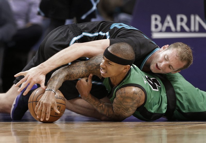 Charlotte Hornets' Cody Zeller, top, and Boston Celtics' Isaiah Thomas, bottom, vie for a loose ball in the second half of an NBA basketball game in Charlotte, N.C., Saturday, April 8, 2017. The Celtics won 121-114. (AP Photo/Chuck Burton)