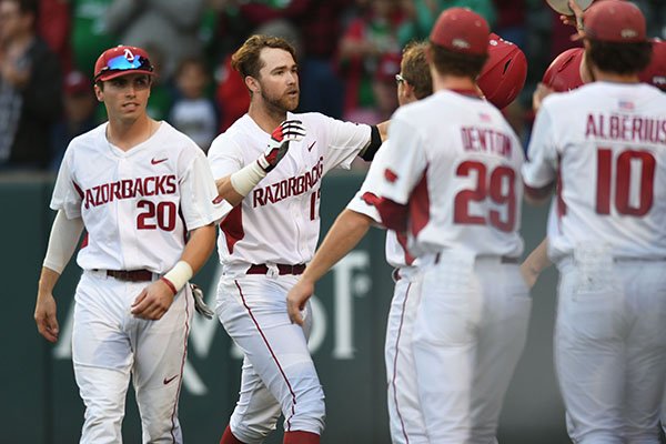 Arkansas left fielder Luke Bonfield (center) is congratulated at the plate by teammates Friday, March 17, 2017, after hitting a 2-run home run scoring Chad Spanberger during the first inning against Mississippi State at Baum Stadium in Fayetteville. Visit nwadg.com/photos to see more photographs from the game.
