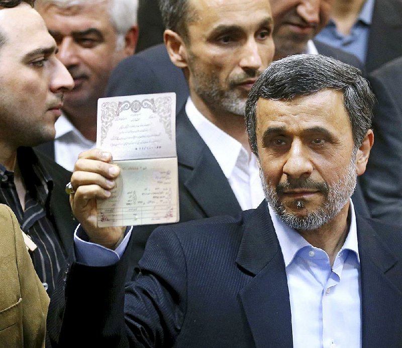 Former Iranian President Mahmoud Ahmadinejad shows his identification Wednesday as he registers to run in the May presidential election. Ahmadinejad’s surprise move came after Supreme Leader Ayatollah Ali Khamenei warned that the candidacy would be “harmful to the country.”  
