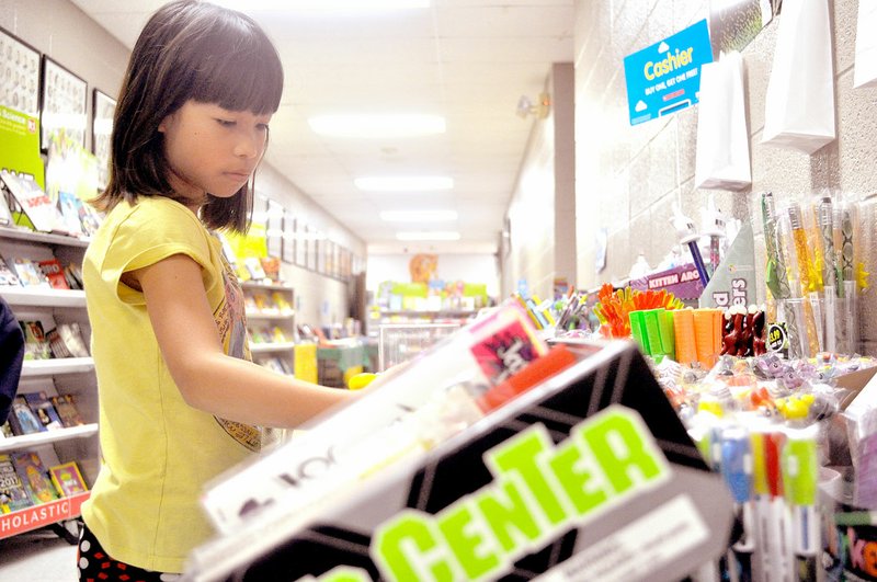 RACHEL DICKERSON/MCDONALD COUNTY PRESS Susie Eh looks at items at the book fair at Noel Elementary. The school also recently had a science fair and an art fair.