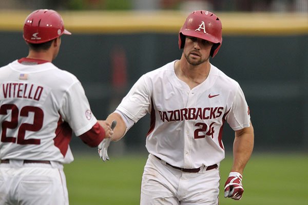 Chad Spanberger (24), Arkansas first baseman, shakes assistant coach Tony Vitello's hand as he rounds third base after hitting a home run Thursday, April 13, 2017, during the first inning against Georgia at Baum Stadium in Fayetteville.
