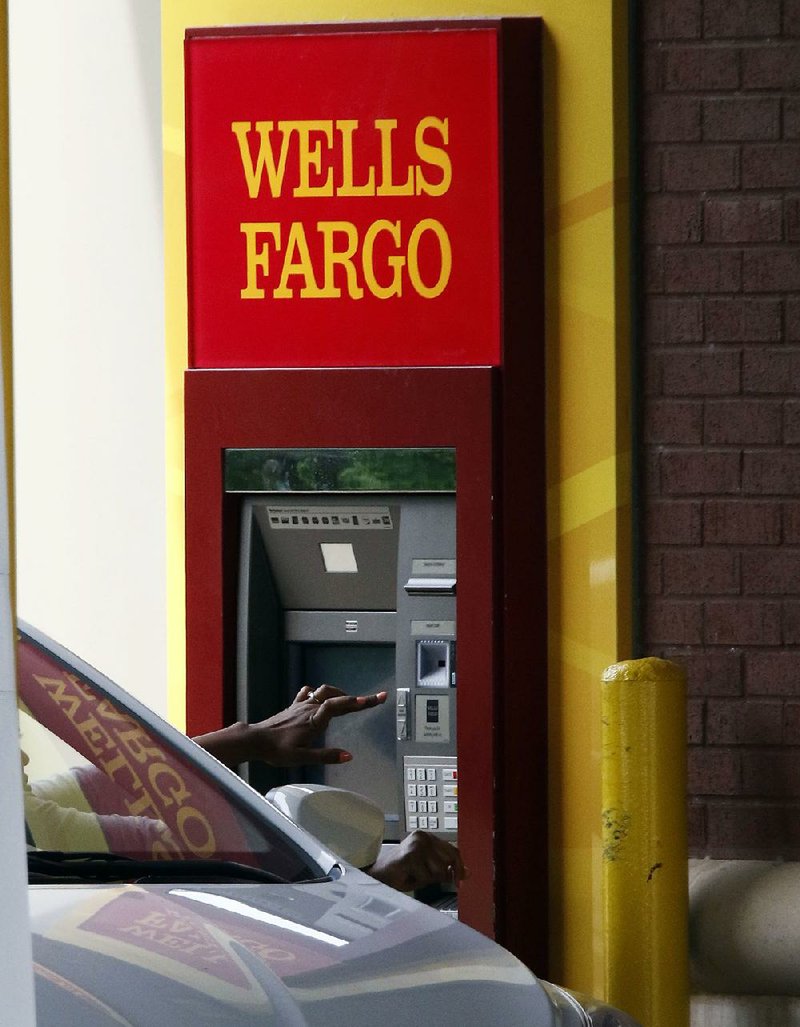 A customer uses an ATM at a Wells Fargo bank in Jackson, Miss., on Tuesday. The bank on Thursday reported a quarterly profit of nearly $5.46 billion, exceeding Wall Street expectations.