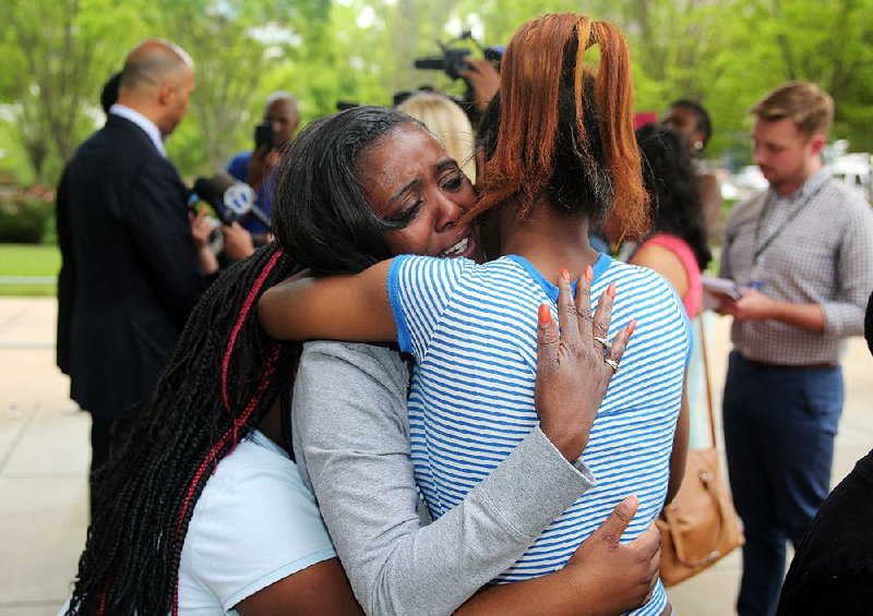 Sylvia Perkins is hugged by family members while her attorney speaks with reporters after a jury decision Thursday in Perkins’ suit against former Little Rock police officer Josh Hastings over the 2012 killing of her son. “I just wanted him to admit what he did,” she said.