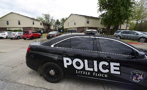 Little Flock police officers and Benton County Sheriffs deputies talk outside an apartment in the Fairways at Lost Springs Apartments complex after two people were shot early Friday morning