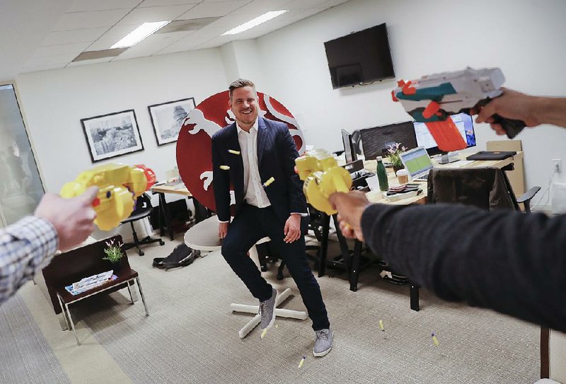 Alex Slater, managing director of Clyde Group, a public relations firm in Washington, is hit with Nerf darts by his employees earlier this month. 