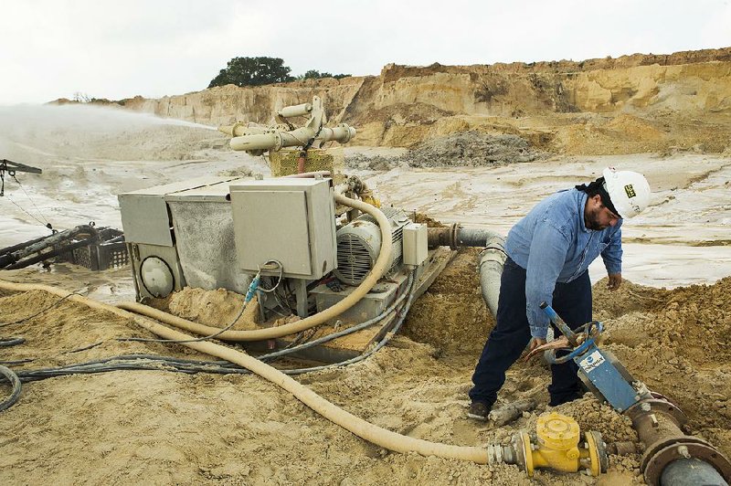 Julio Griffin adjusts the water pressure on a hydro-cannon at the Superior Silica Sands mine late last month in Kosse, Texas. 