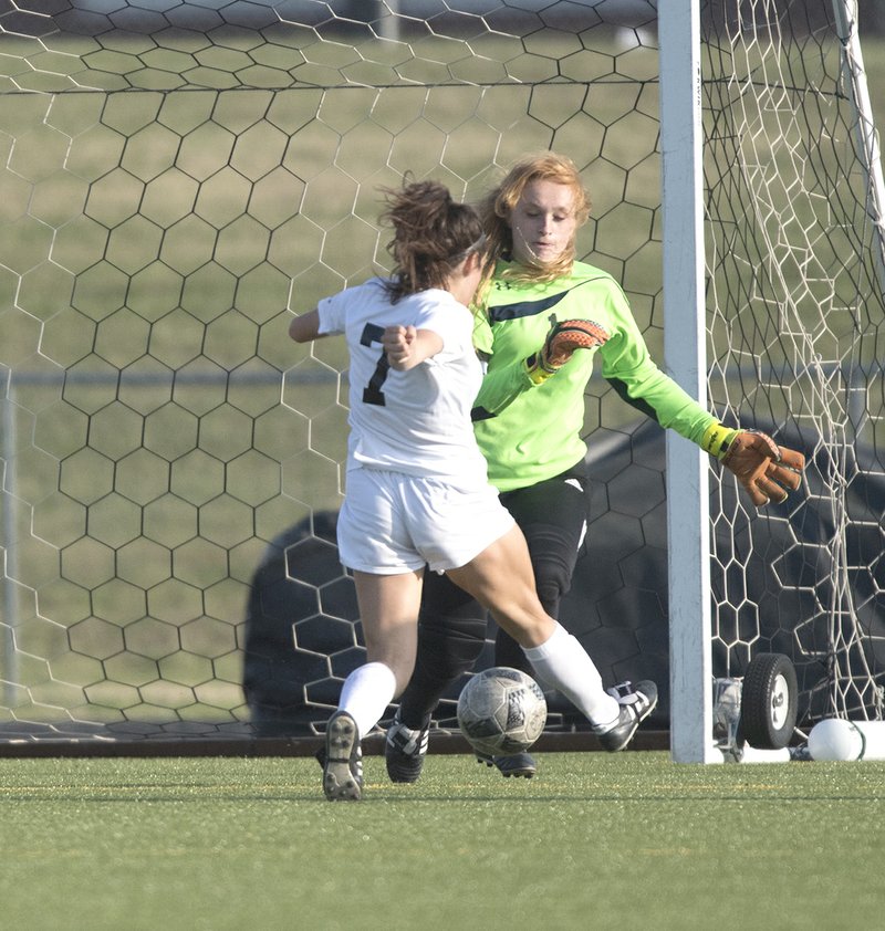 NWA Democrat-Gazette/J.T. WAMPLER Bentonville High's Angelina Diaz (7) bears down on and beats Fayetteville keeper Gracie Cape on Friday at Bentonville.