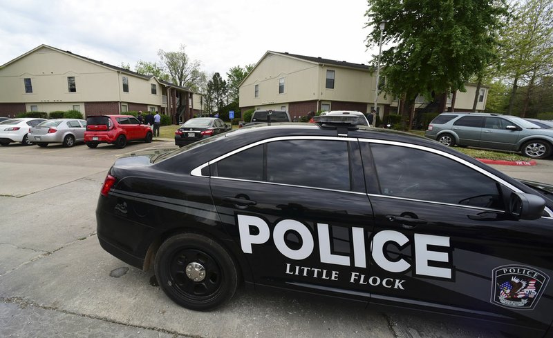 Little Flock police officers and Benton County Sheriff’s Office deputies talk Friday outside an apartment in the Fairways at Lost Springs complex after two people were shot early Friday morning in Little Flock.