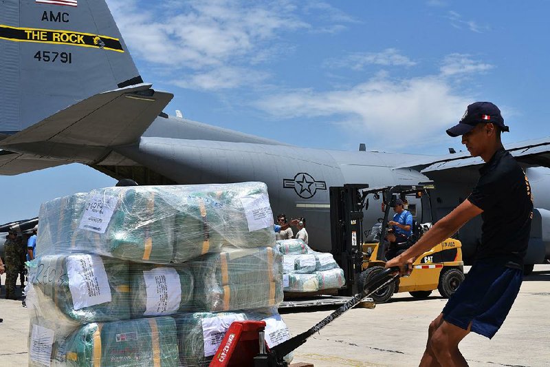 Cargo provided by the U.S. Agency for International Development is unloaded from an Air Force plane by Peruvian workers in Lima, Peru, earlier this month. Two C-130 aircraft from Little Rock Air Force Base are transporting supplies and personnel to flood-damaged regions of the South American country. 