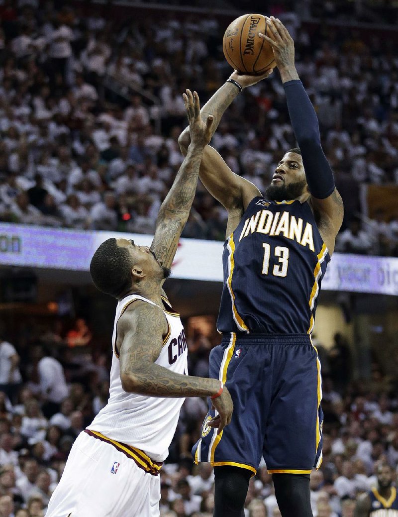 Indiana forward Paul George (13) shoots over Cleveland’s J.R. Smith in the second half of the Cavaliers’ 109-108 victory in the first game of their NBA Eastern Conference series against the Pacers. George had a team-high 29 points for the Pacers. 