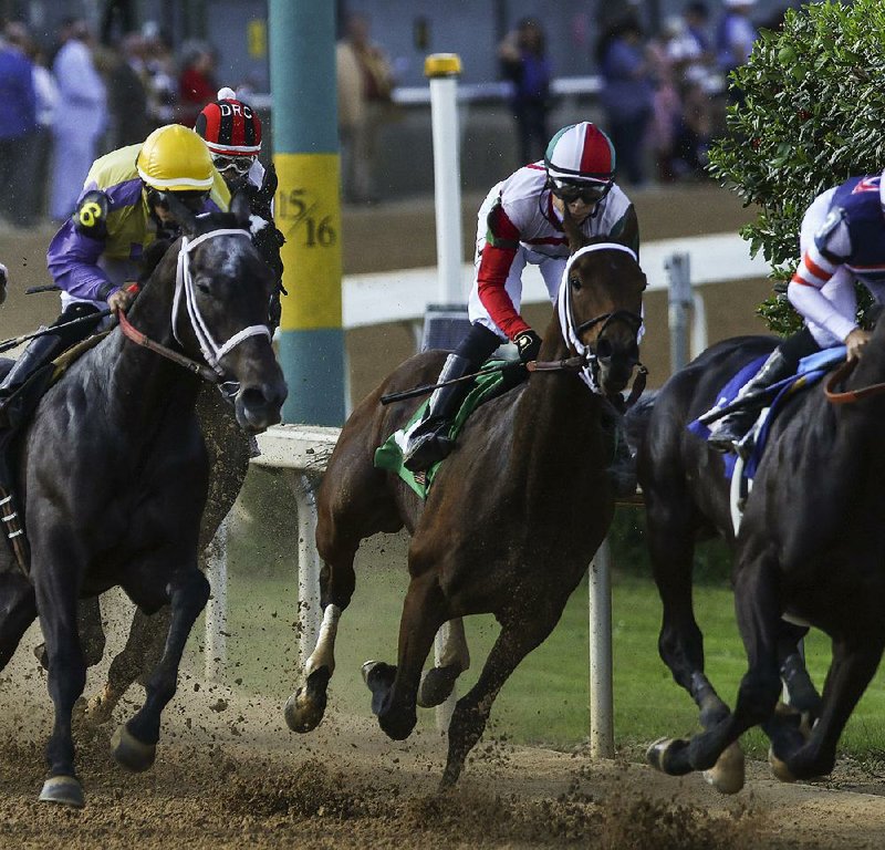 Inside Straight, ridden by Jockey Geovanni Franco (center), hits the fi rst turn during Saturday’s Oaklawn Handicap. Inside Straight won the 1 1/8-mile race in 1:48.40 by 2 lengths over Domain’s Rap.