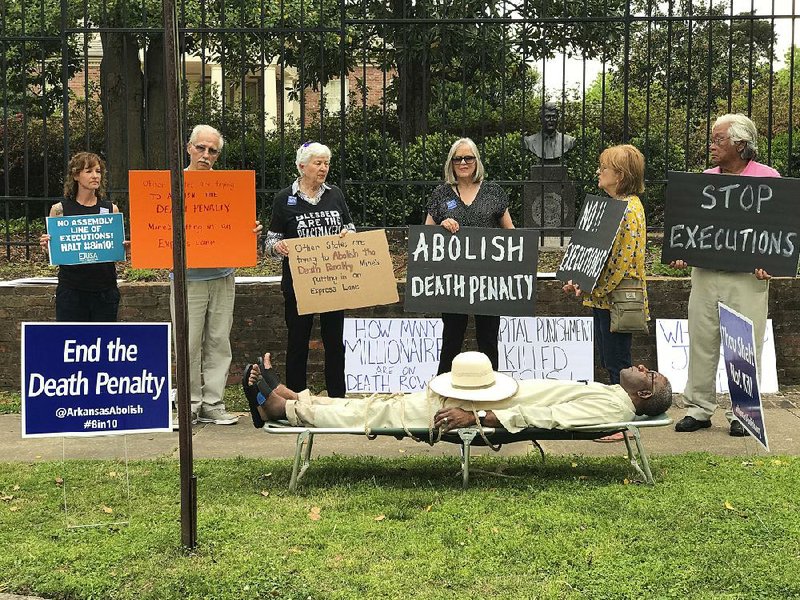 Pulaski County Circuit Judge Wendell Griffen lies on a cot outside the Governor’s Mansion during a protest against the death penalty Friday. Griffen, who issued a restraining order Friday in a lawsuit by the maker of one of the lethal drugs that would be used in the execution of Arkansas inmates, has come under heavy criticism from death-penalty proponents for taking part in the protest.