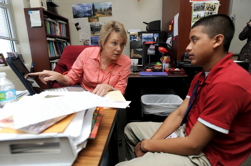 Instructor Jeanie Nance (left) helps Juan Zacharias, 17, on Thursday with translating a paragraph into English in the language academy meant for English language learners at Har-Ber High School in Springdale. A new law, Act 991, changes testing and performance requirements for English language learners in the state’s academic accountability system.