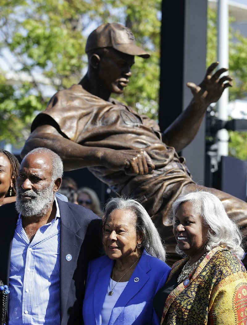 Jackie Robinson’s widow Rachel Robinson (center) poses with her son David and daughter Sharon in front of a bronze statue of Robinson on Saturday outside Dodger Stadium in Los Angeles.