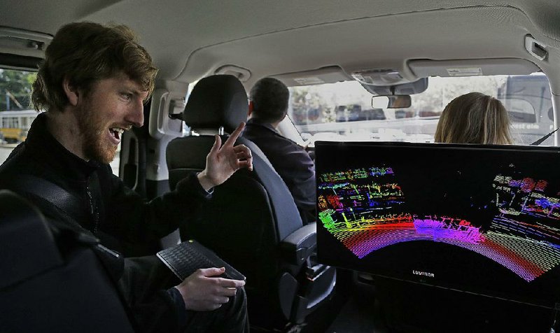 Luminar CEO Austin Russell (left) looks at data on a 3-D lidar map developed by his company during a demonstration drive in San Francisco earlier this month.