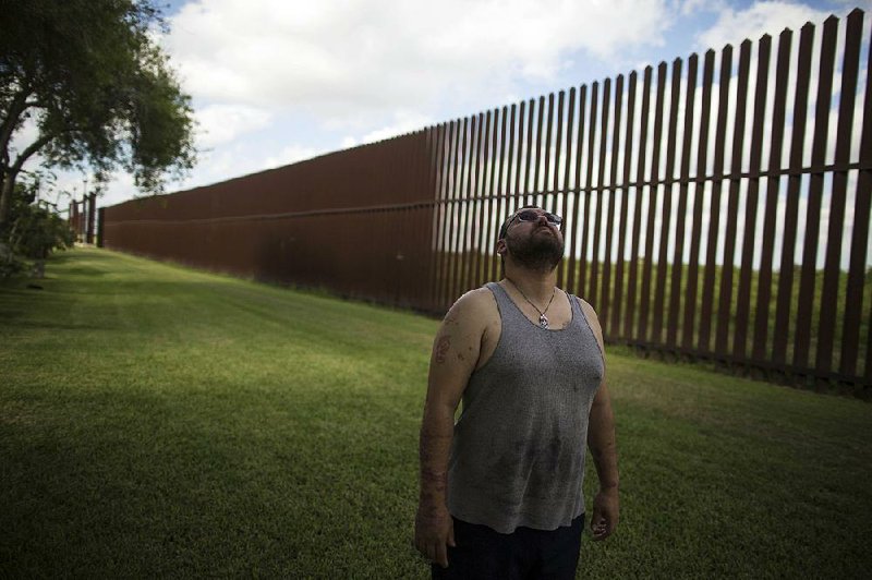 American citizen Antonio Reyes stands by the U.S.-Mexico border fence where his home is located in Brownsville, Texas.