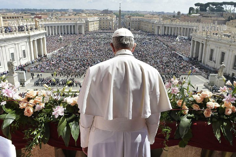 Pope Francis addresses the crowd before delivering his Easter message from the main balcony of St. Peter’s Basilica at the Vatican on Sunday.