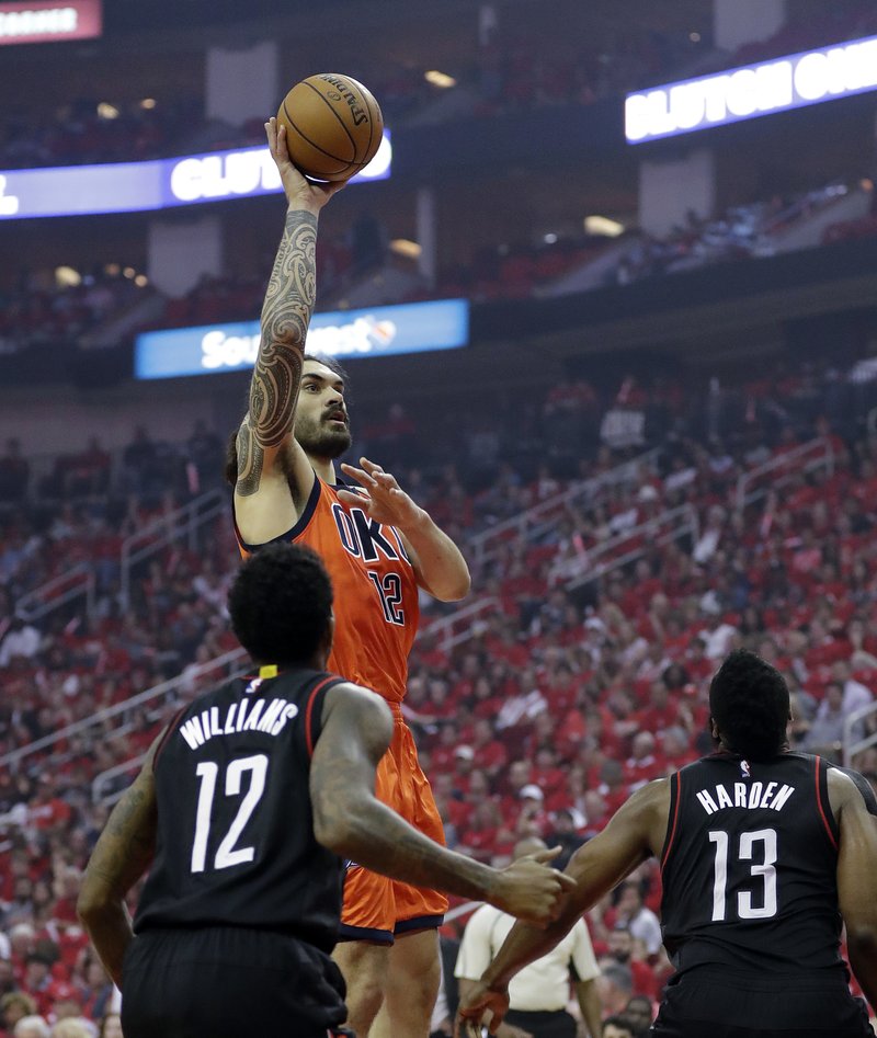 Oklahoma City Thunder's Steven Adams shoots against Houston Rockets' Lou Williams (12) and James Harden (13) during the first half of Game 1 of an NBA basketball first-round playoff series, Sunday, April 16, 2017, in Houston. 